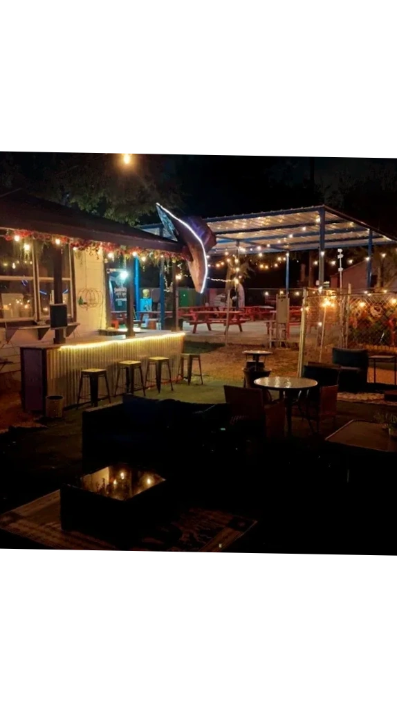 The Mad Rabbit outdoor seating and bar glowing under warm evening lights